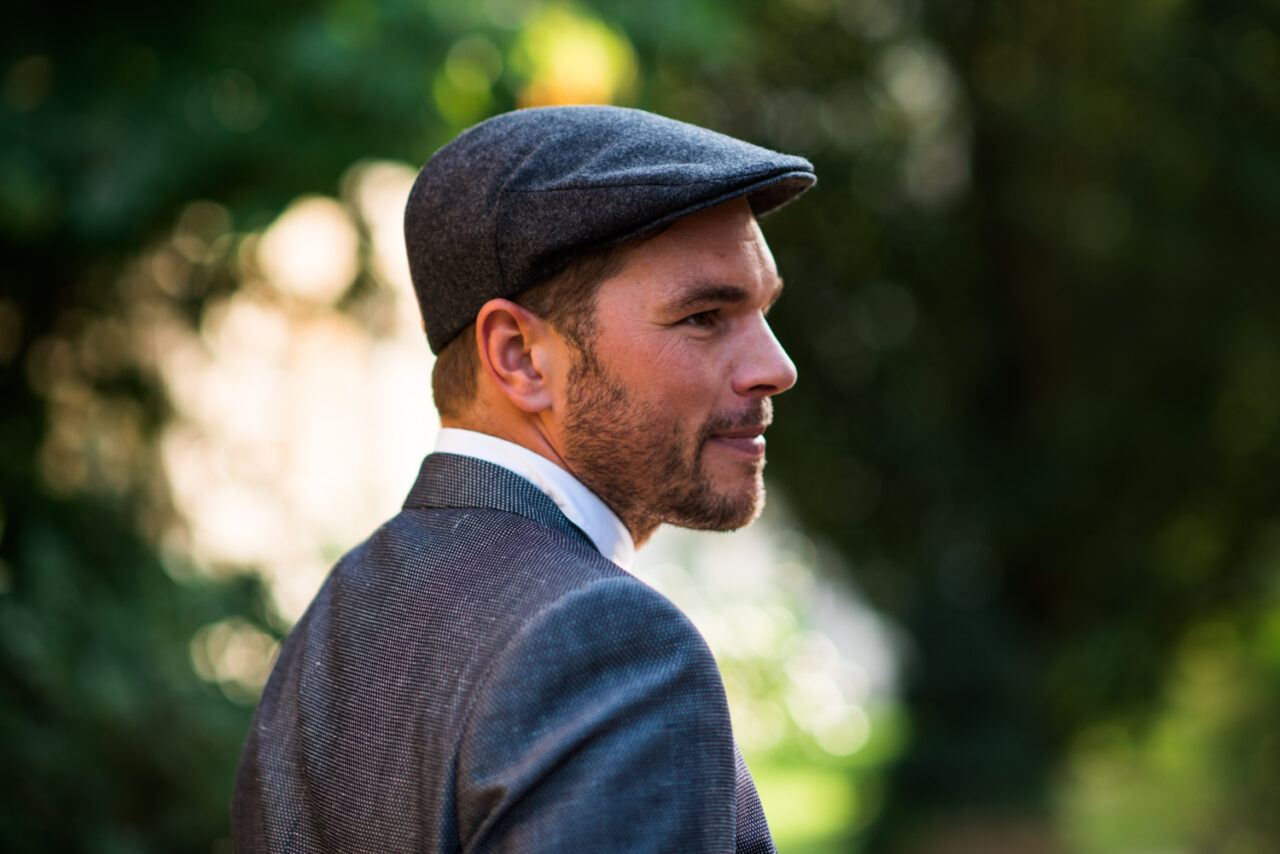 A wedding guest wearing a cap.