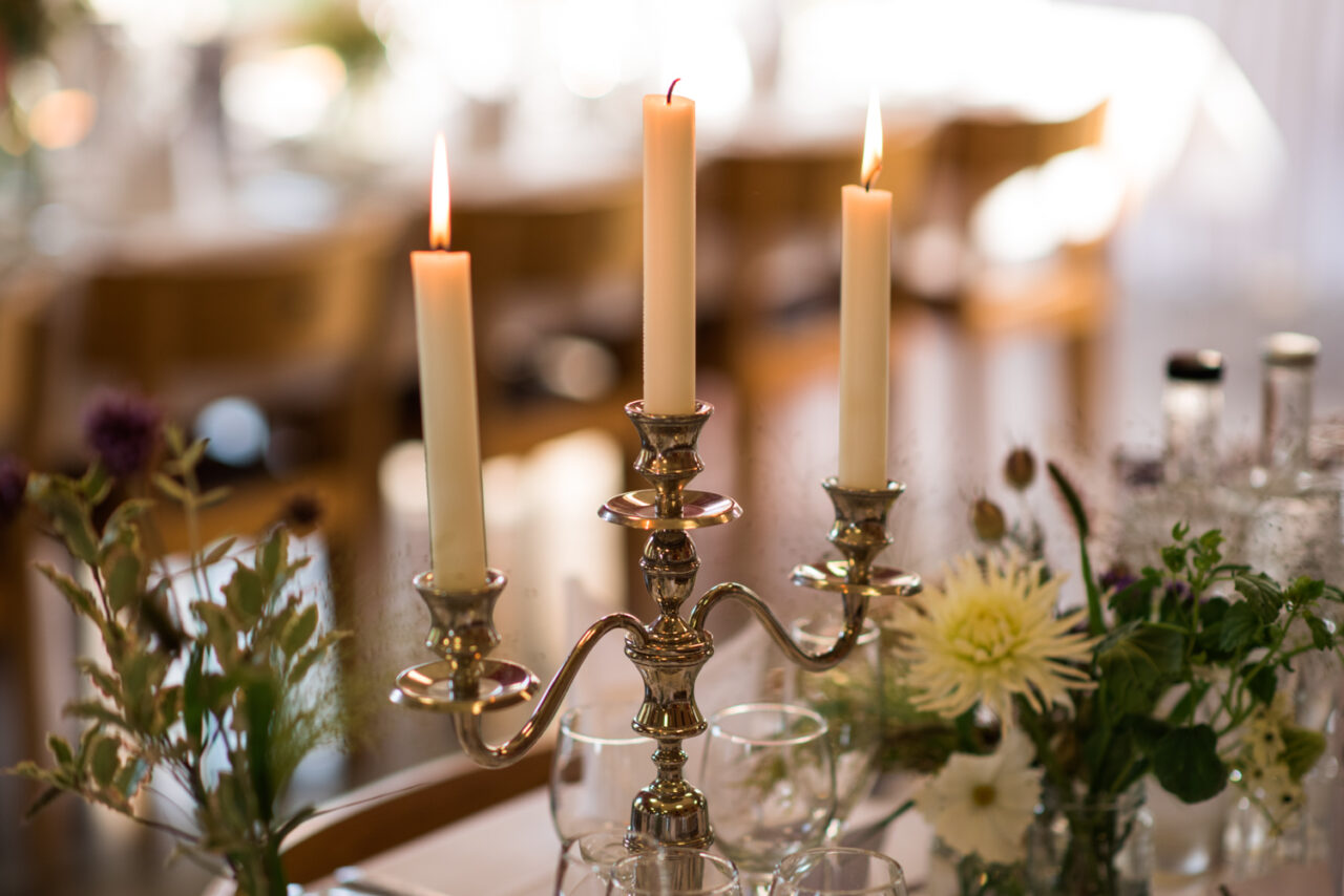 Candles on a table ready for the wedding breakfast in the hall at Downing.