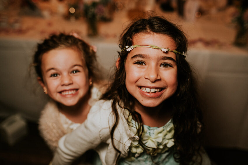 Portrait of two smiling girls at a wedding.