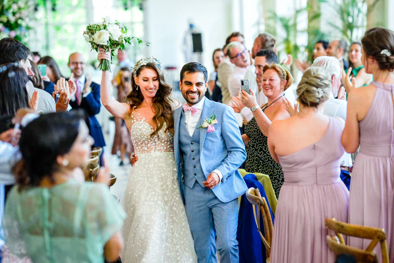 Documentary wedding photography. A bride and groom walk into their wedding breakfast.