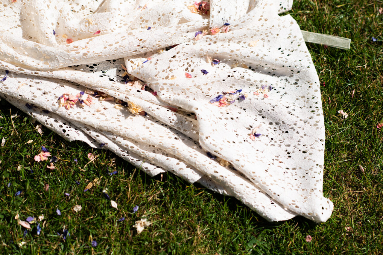 Documentary wedding photo of a bride's wedding dress covered in confetti.