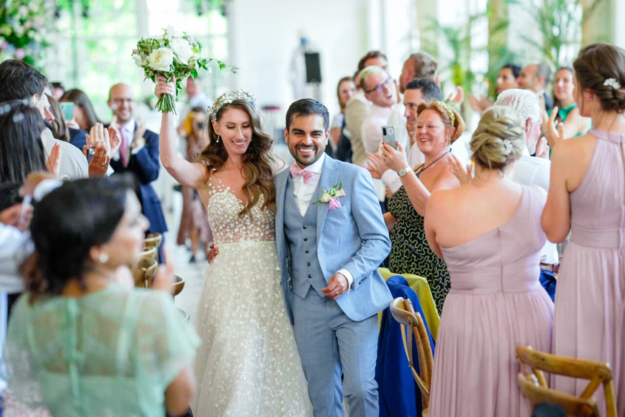 Kew Gardens Wedding Photos - Bride and groom are cheered by their friends and family at the start of their wedding breakfast.