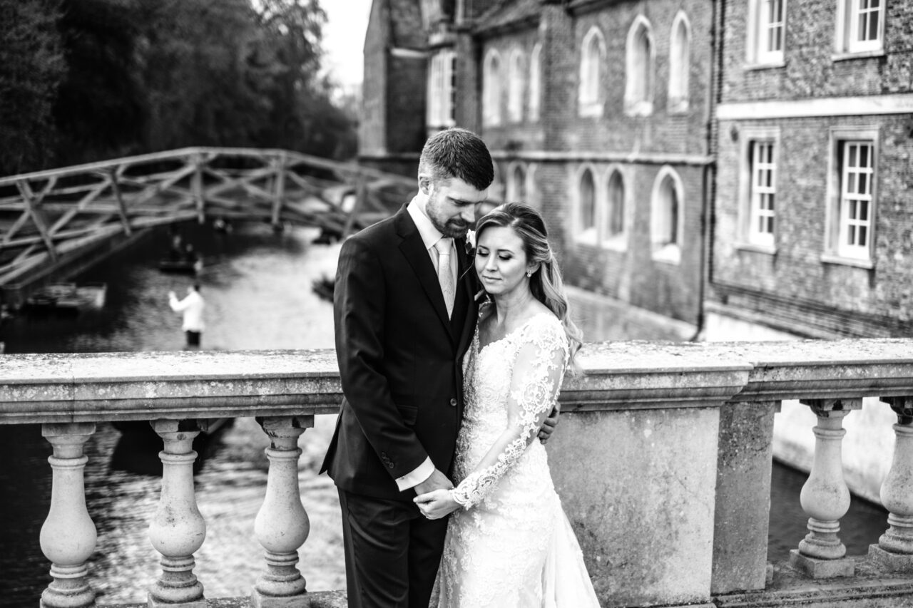 Bride and groom on Silver Street Bridge in Cambridge with Queens' College and the Mathematical Bridge in the background.