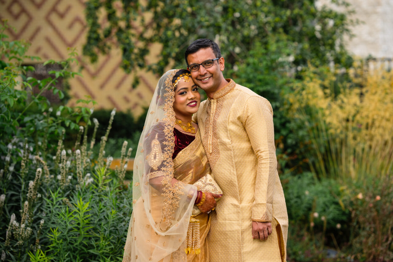 A bride and groom embrace in the grounds of Cambridge Central Mosque after their nikah wedding ceremony.