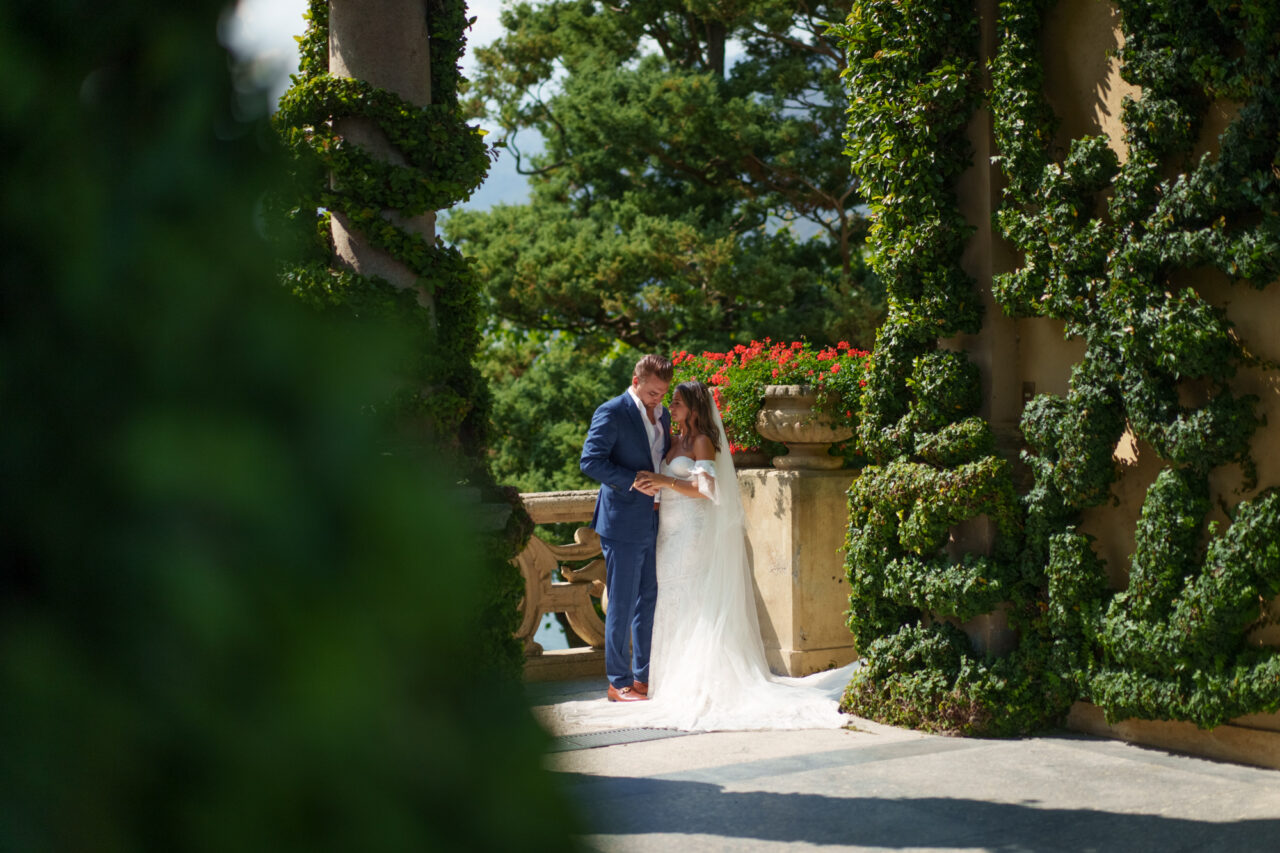 A bride and groom holding hands at Villa del Balbianello, Lake Como.