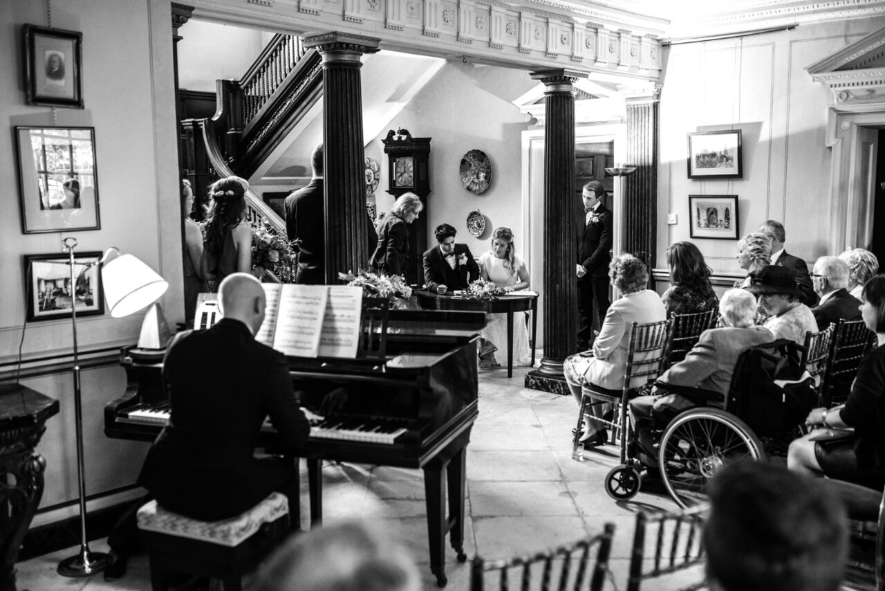 Black and white wedding photo of an indoors wedding ceremony.