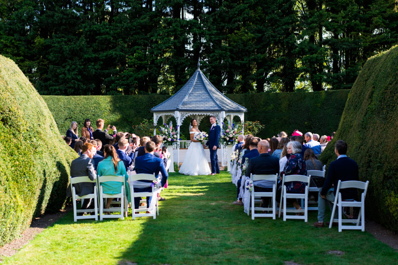 Hockwold Hall wedding photo of a ceremony outside in the bright sunshine