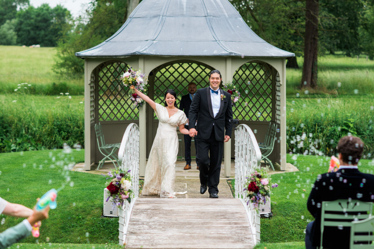 Bride and groom celebrating after their outside wedding ceremony at Longstowe Hall.