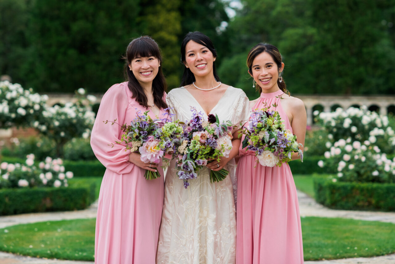 A bride and her bridesmaids pose for a photo in gardens of Longstowe Hall.