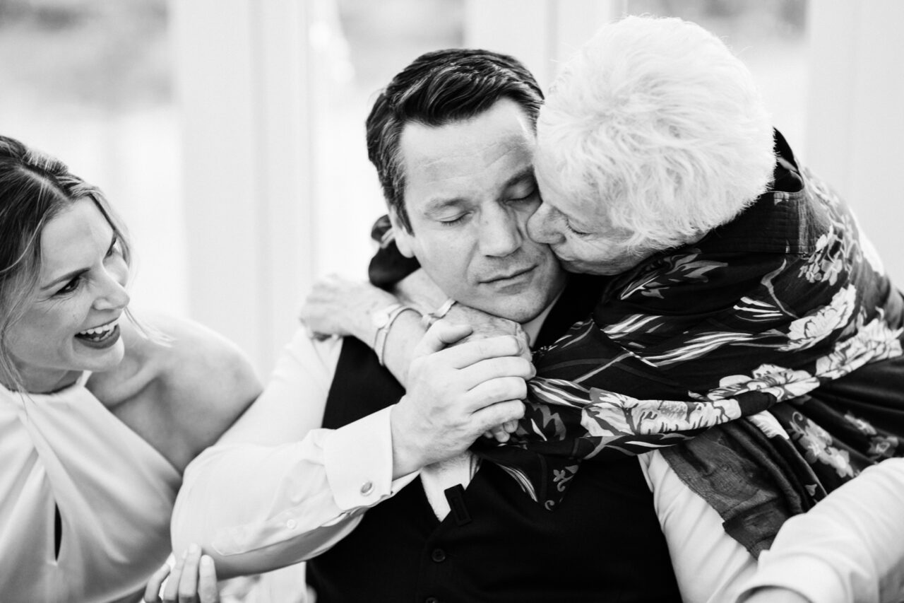 A candid photo of a groom and his mother embracing during the wedding reception at Longstowe Hall.