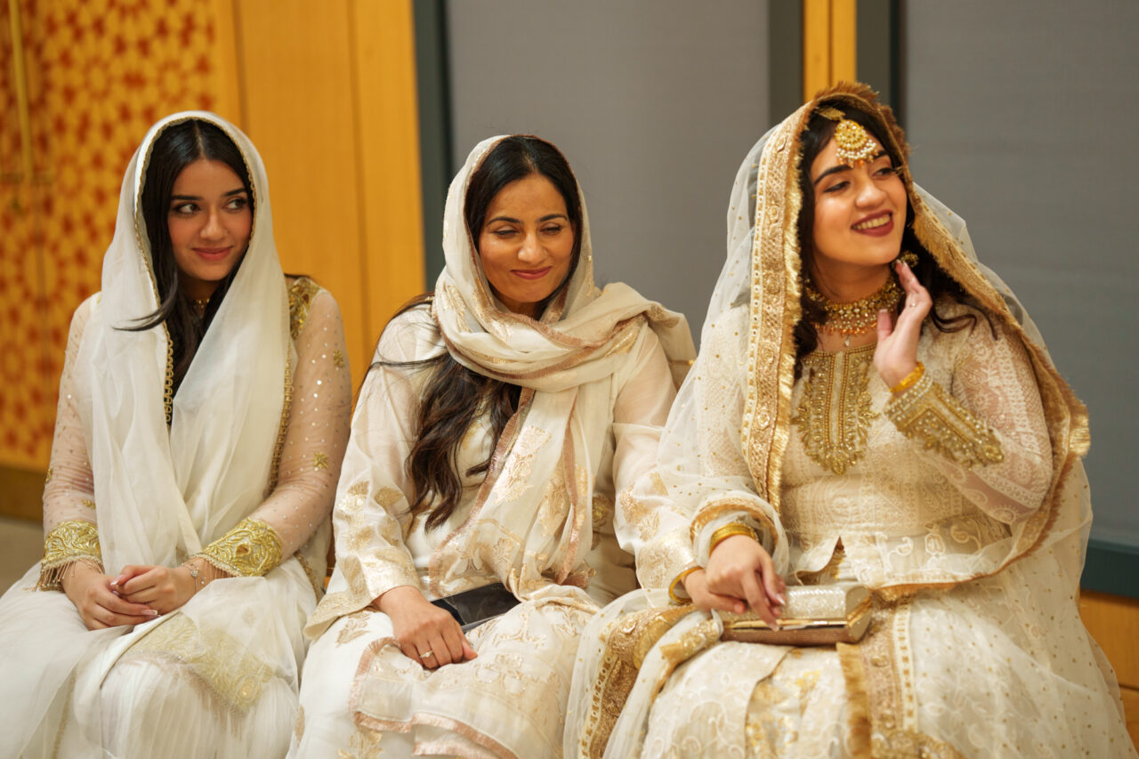 A bride and two female relatives sit together during a nikah wedding ceremony in Cambridge.