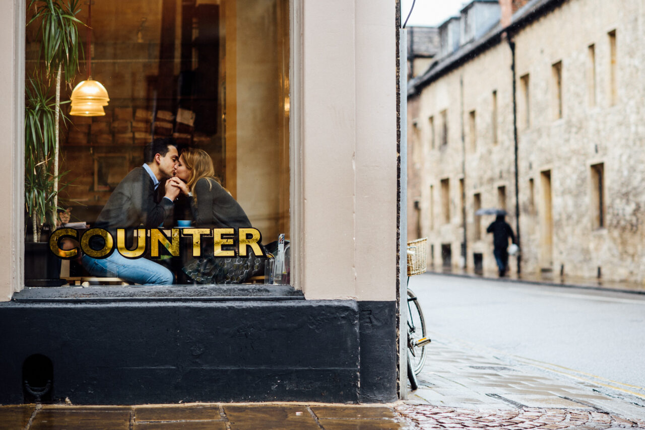 A couple kiss in the window of Fitzbillies on Trumpington Street in Cambridge.