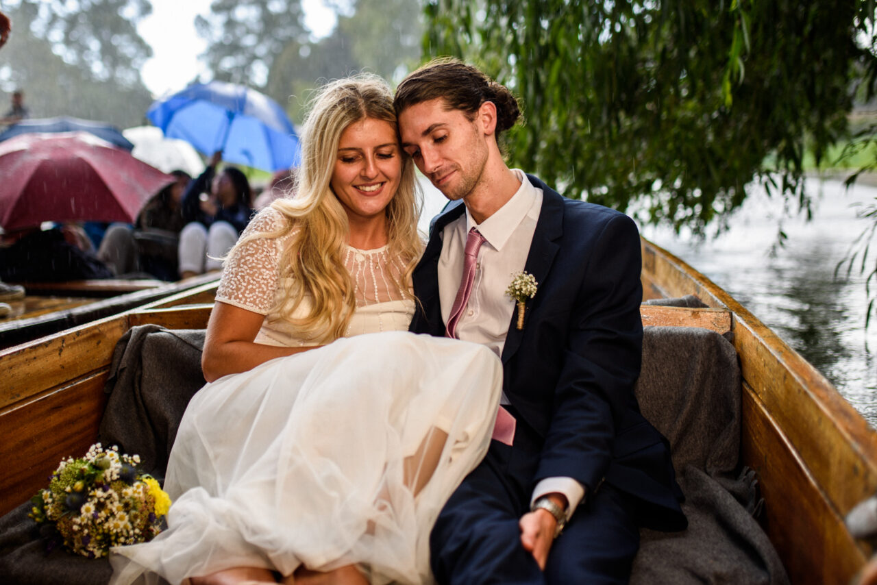 A bride and groom in a punt on the River Cam.