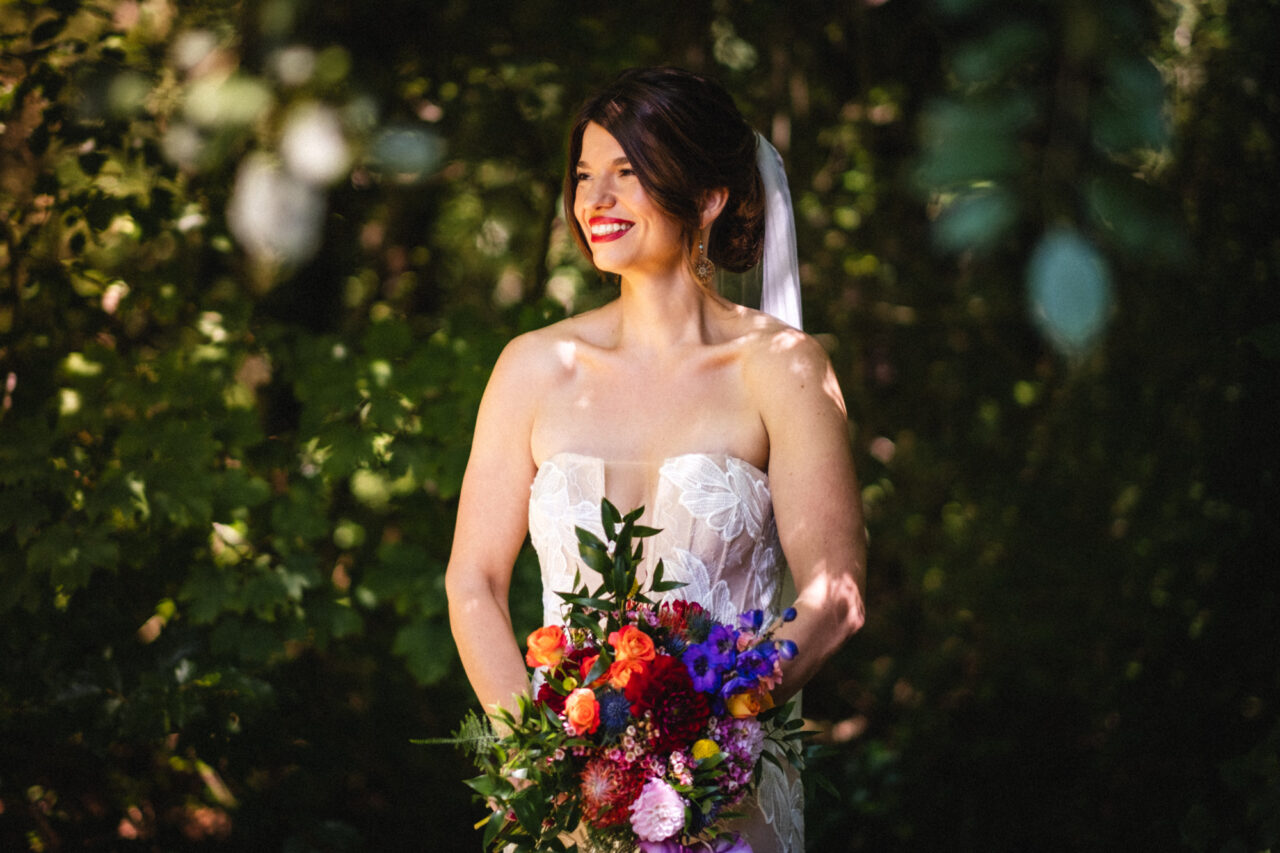 A bride poses with flowers in the Cambridgeshire countryside.