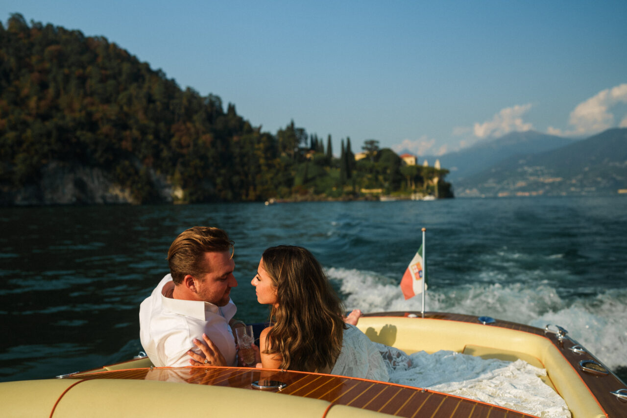 A bride and groom riding on a boat on Lake Como in Italy.