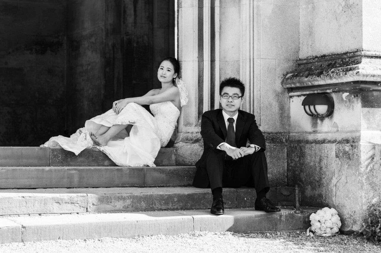 A bride and groom pose on the steps of St John's College on their pre-wedding photoshoot.