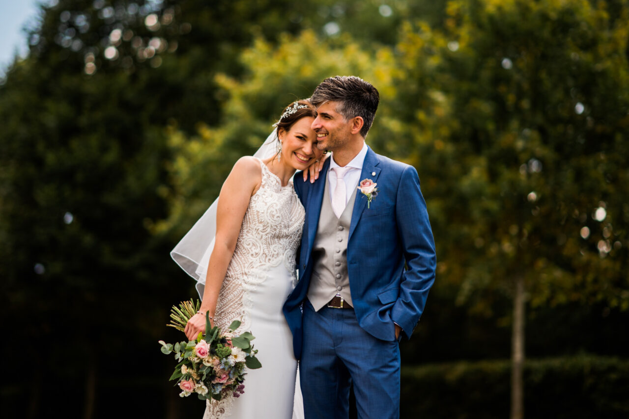 Cambridge wedding photographer - a bride and groom embrace in the grounds of The Old Hall in Cambridgeshire.