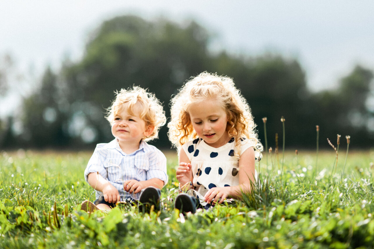 Brother and sister playing in a field.