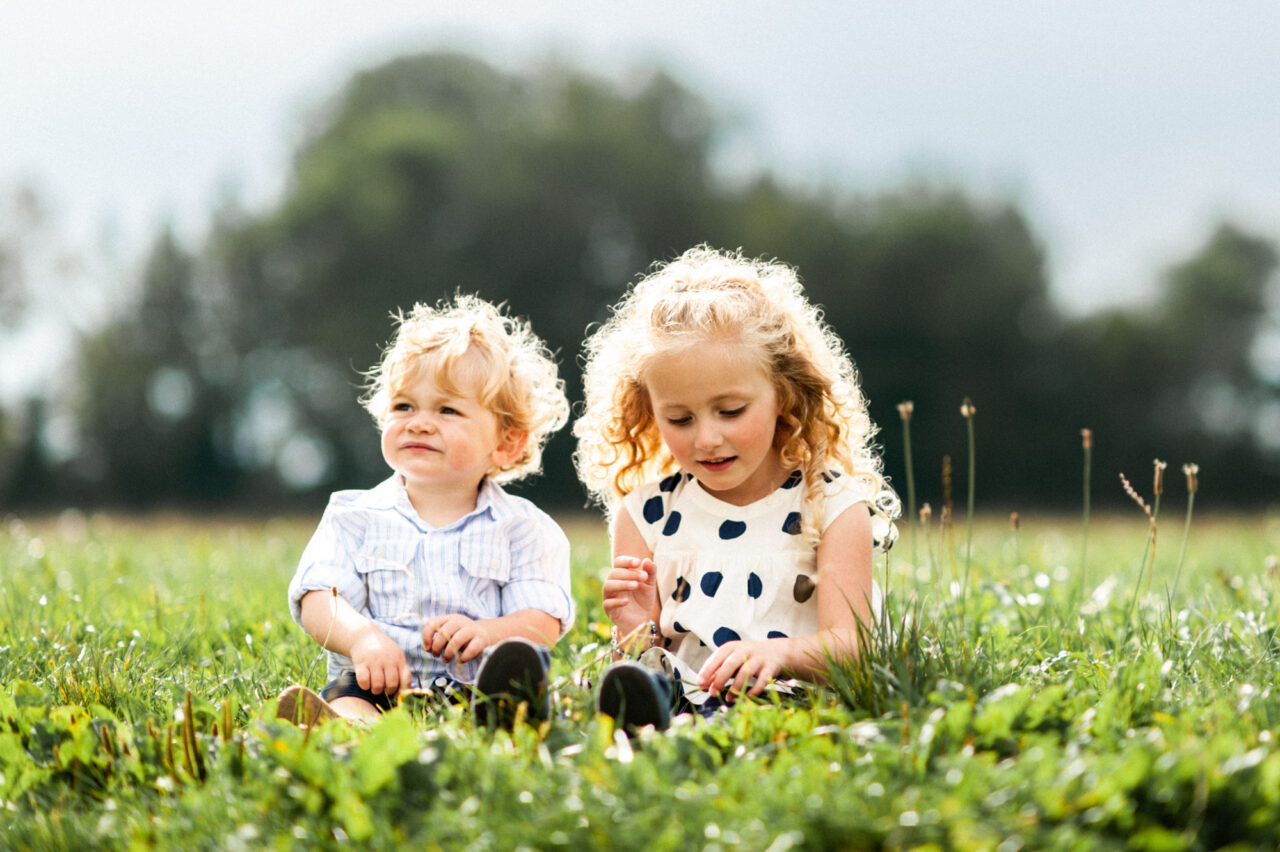 Brother and sister playing in a field.