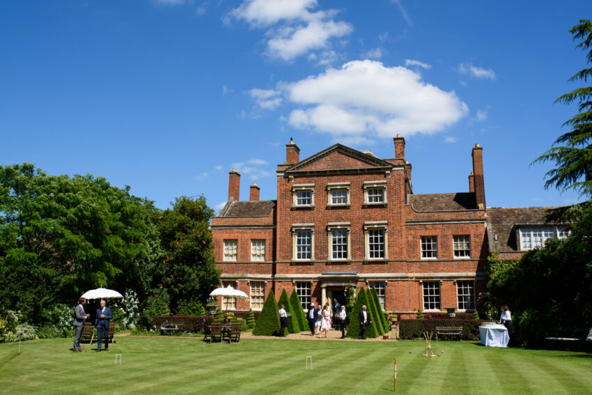 Exterior view of the Georgian house and lawns at Island Hall wedding venue Cambridgeshire.
