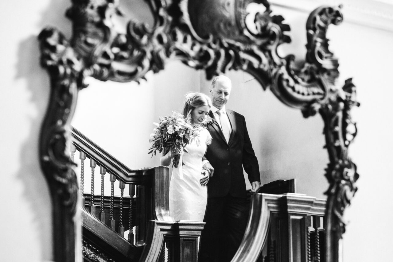 A bride and her father walk down the stairs at Island Hal.