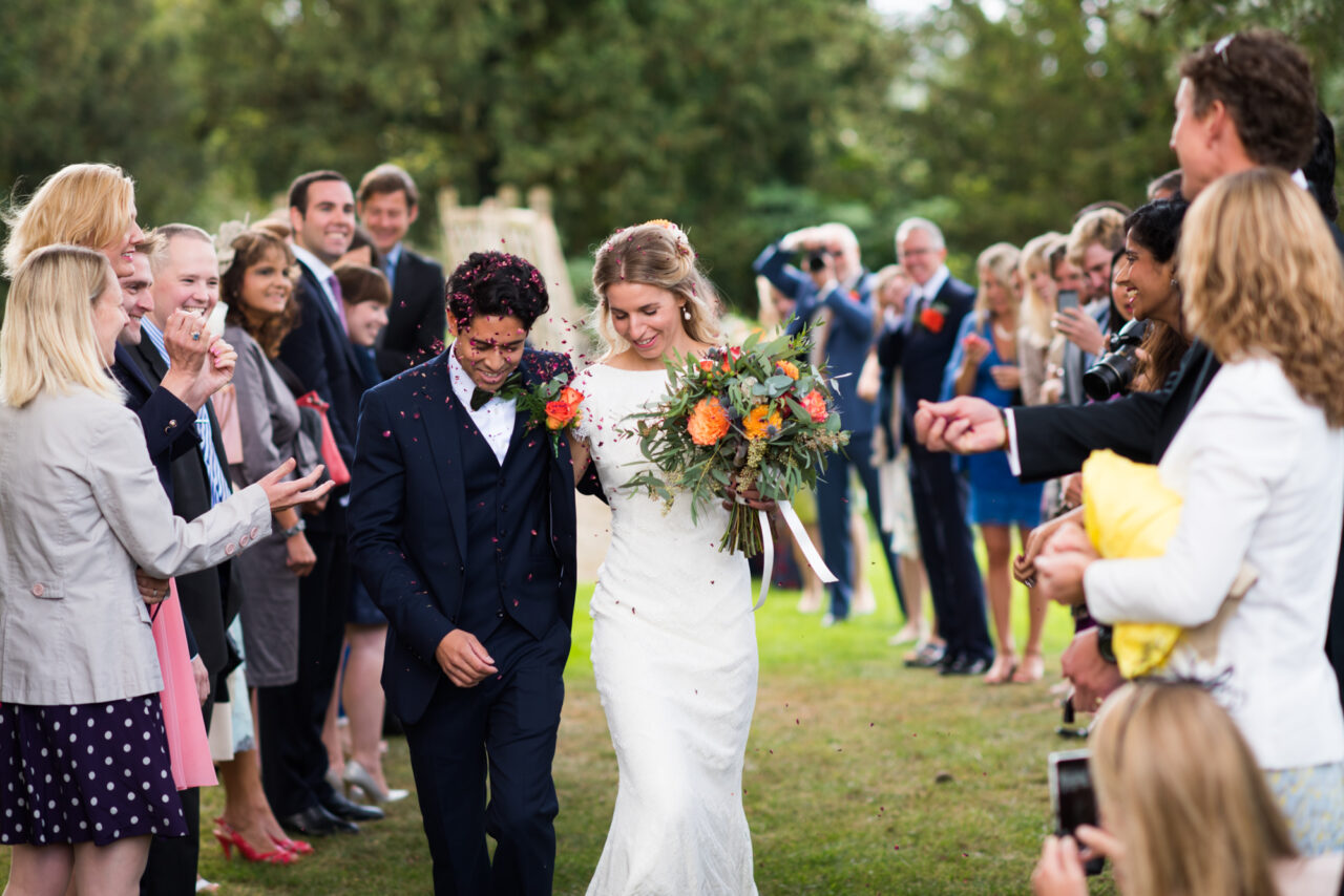 A bride and groom are showered with confetti at Island Hall.