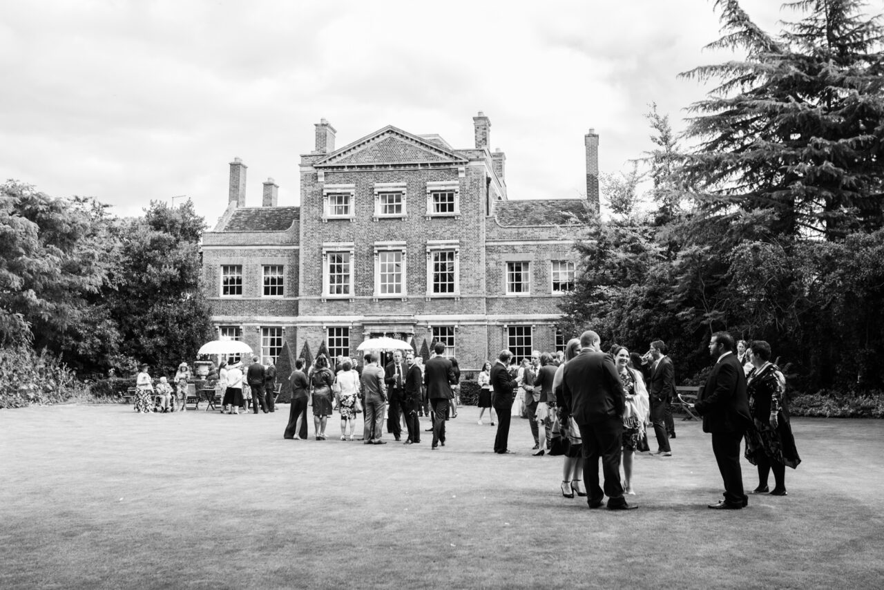 Island Hall house pictured from the gardens with wedding guests.