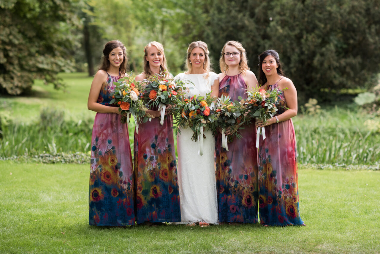 A bride and her bridesmaids in the garden of Island Hall in Cambridgeshire.