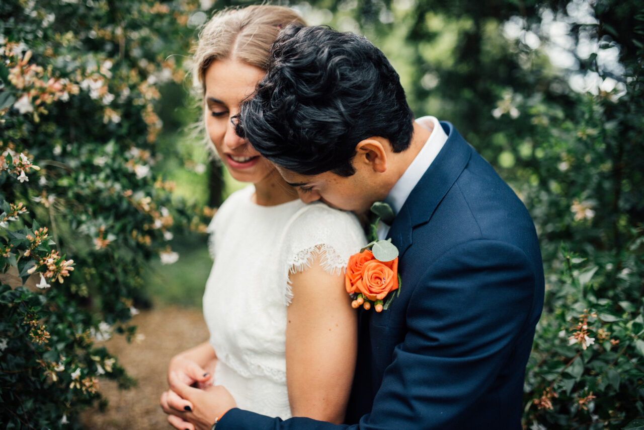 A bride and groom embrace in the garden of Island Hall in Godmanchester.