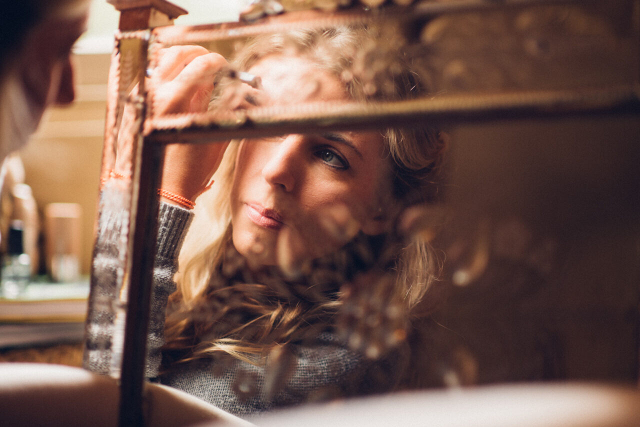 The reflection of a bride in a mirror as she gets ready for her wedding at Island Hall.