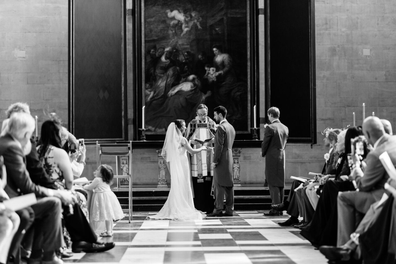 A bride and groom exchange rings during a wedding service at King's College.