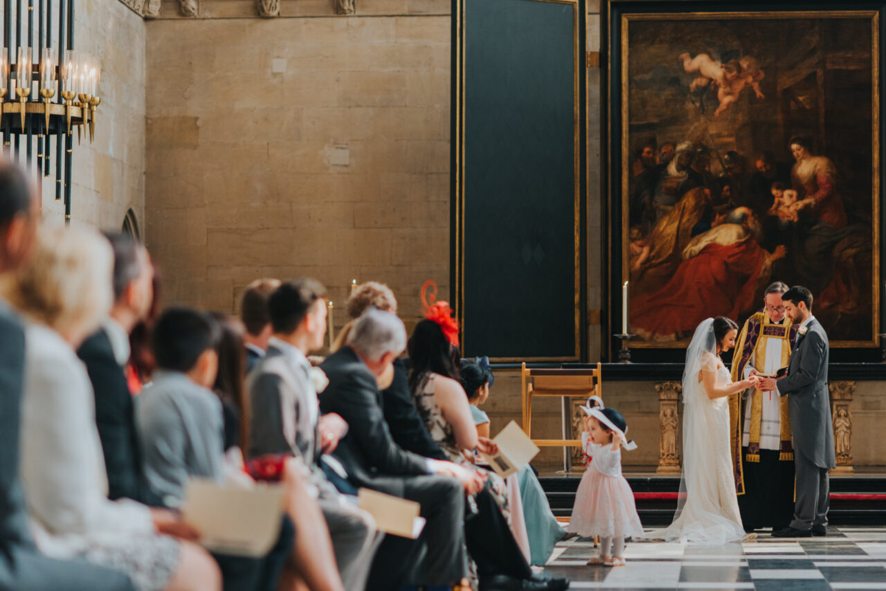 A bride and groom exchange rings during a wedding service at King's College.