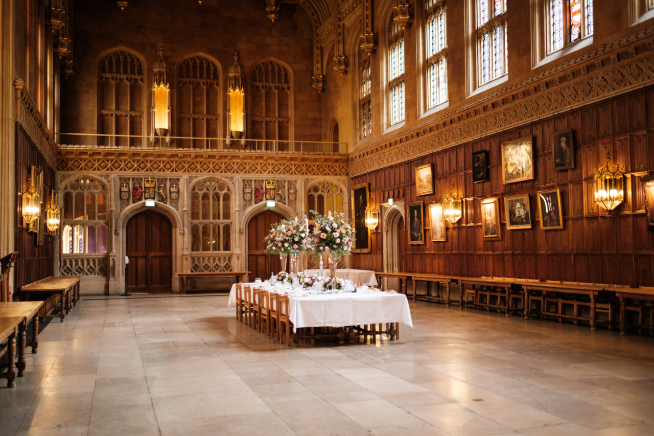 A wedding reception at King's College Hall - a table is laid with flowers on it.