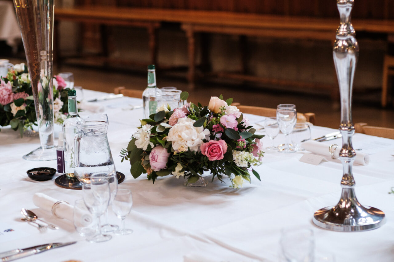 A wedding bouquet of flowers on the table inside King's College Hall.