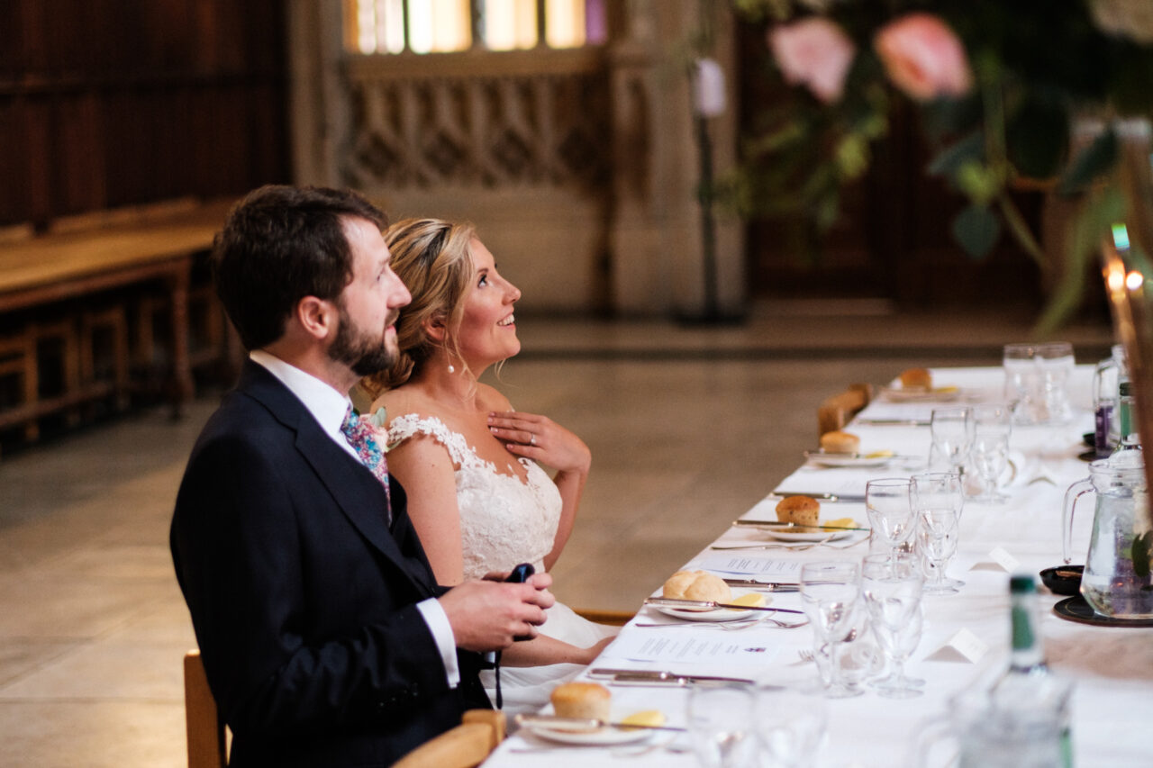 King's College wedding - a bride and groom look at the beautiful flowers on their table.