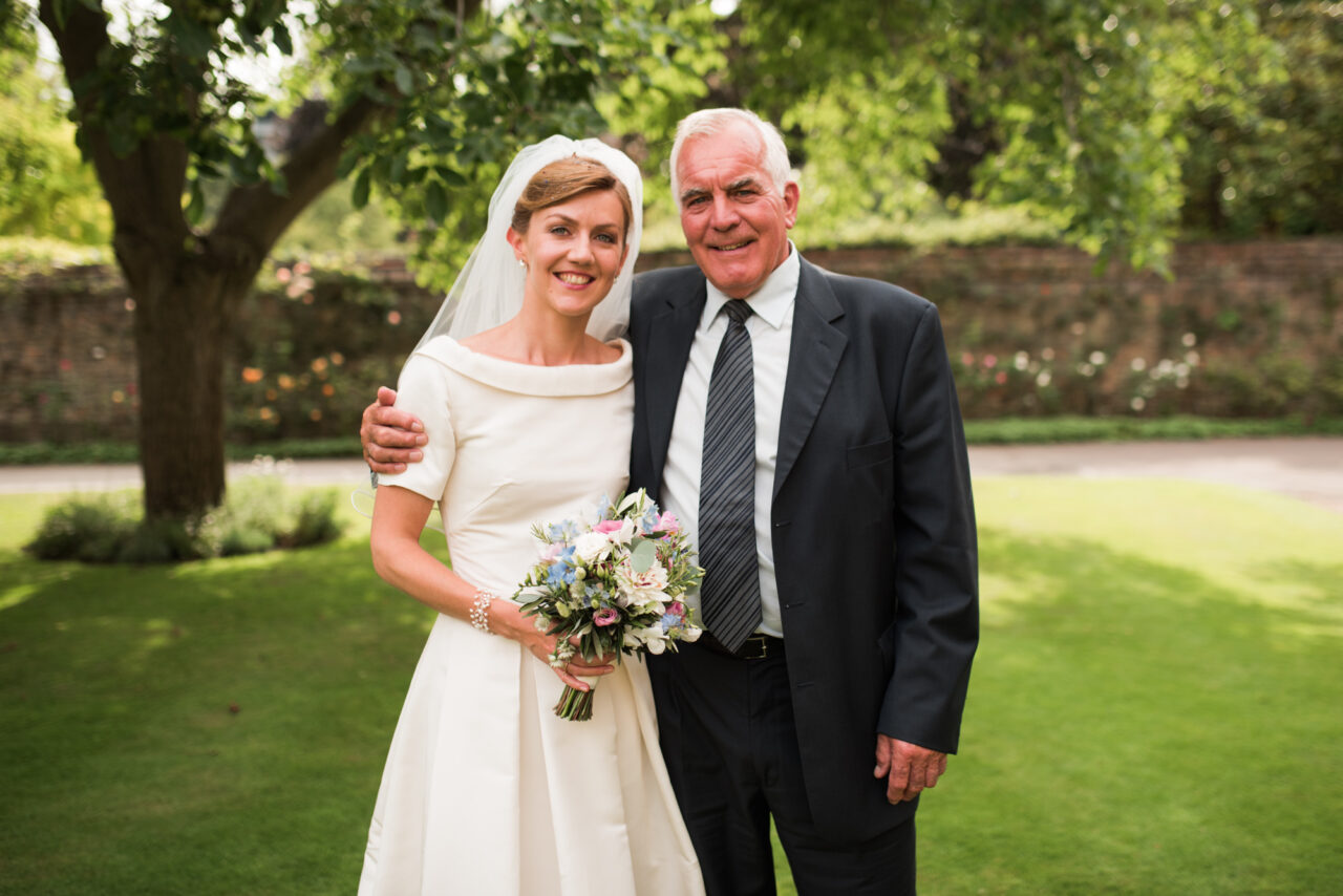 Family wedding photo in the grounds of Queens College.