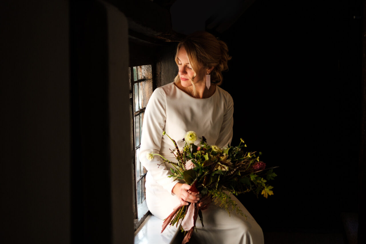 A bride sitting by a window.