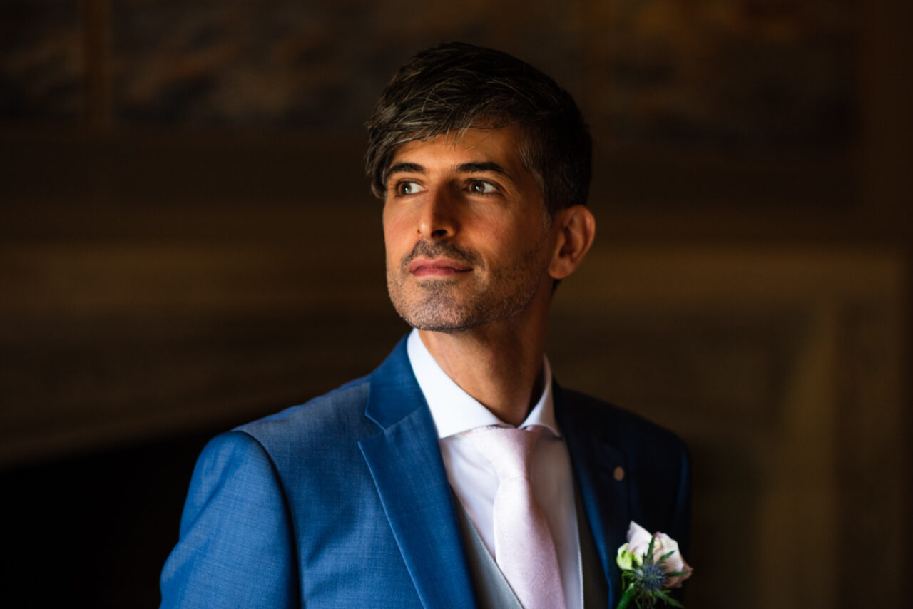 A portrait of a groom in soft window light.