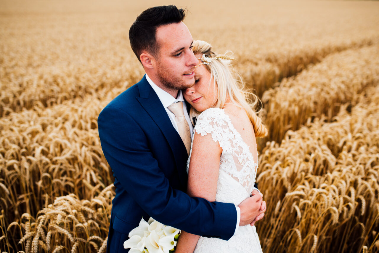 St Ives Wedding Photographer - a couple embrace in a field.