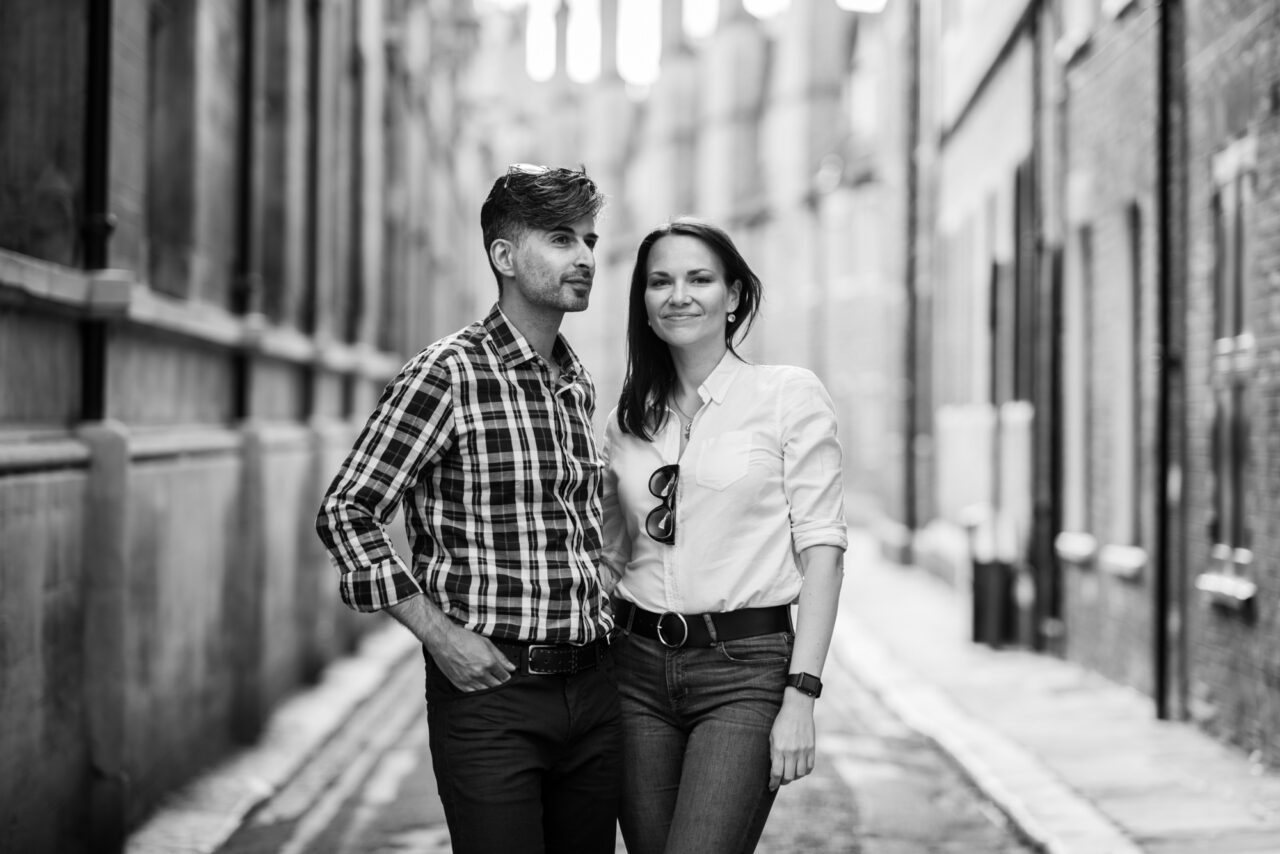 A couple pose for an engagement photo in Trinity Lane in cambridge.