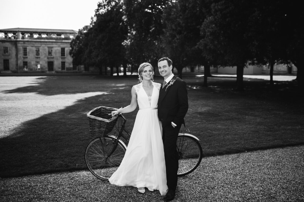 A couple pose on their wedding day with a bike.