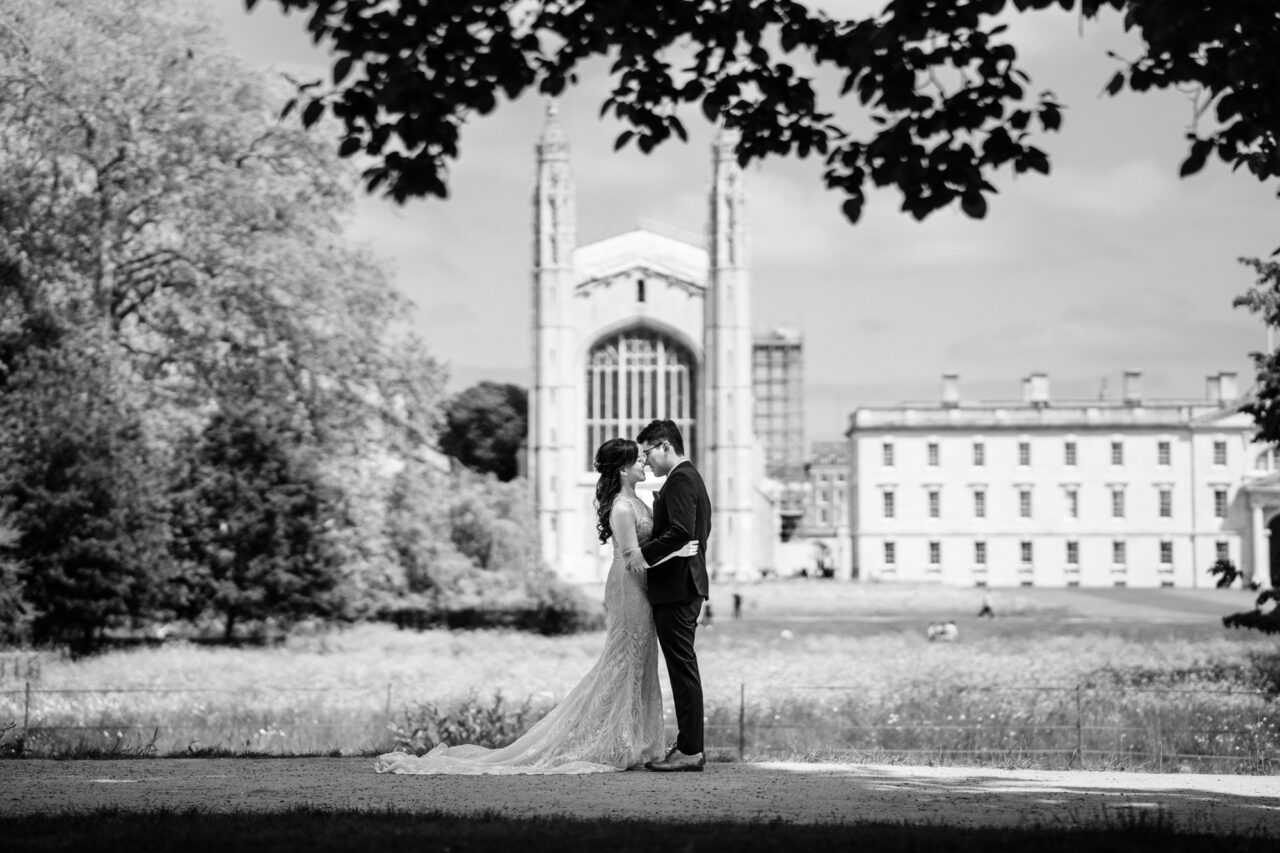 A couple embrace in cambridge with King's College behind them.