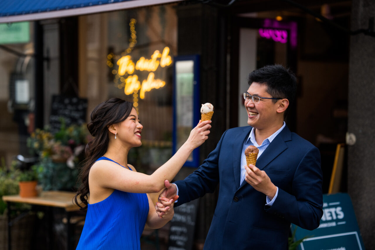 A couple play as they eat ice creams from a cone on King's Parade in Cambridge.