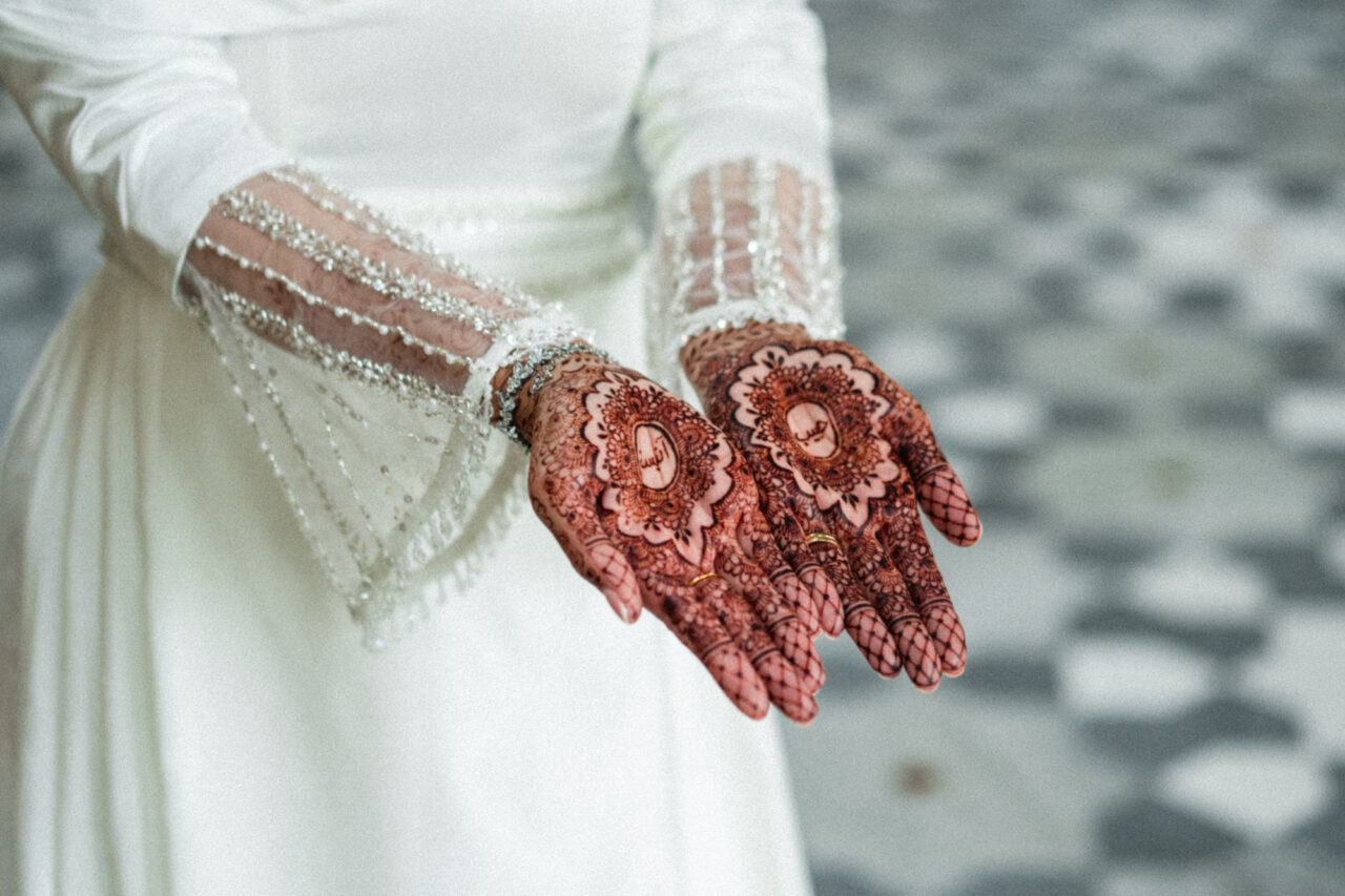 A bride holds out her hands showing her mehndi.