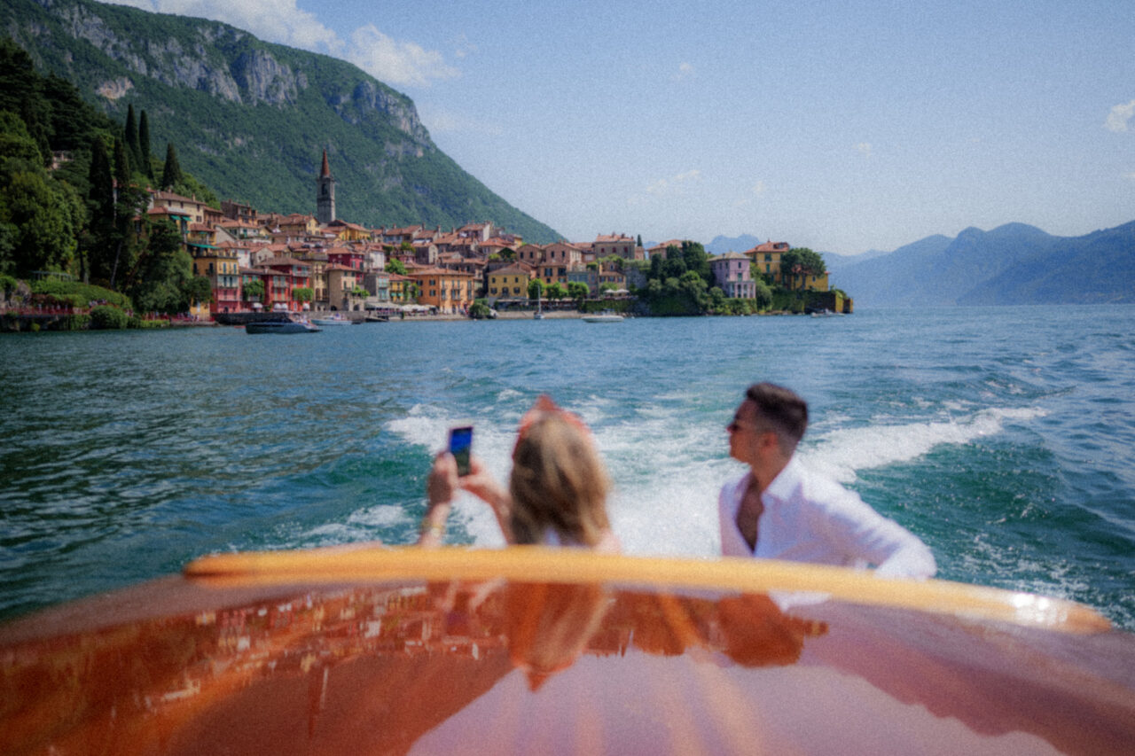 A couple photographed on a boat with Varenna in the background.