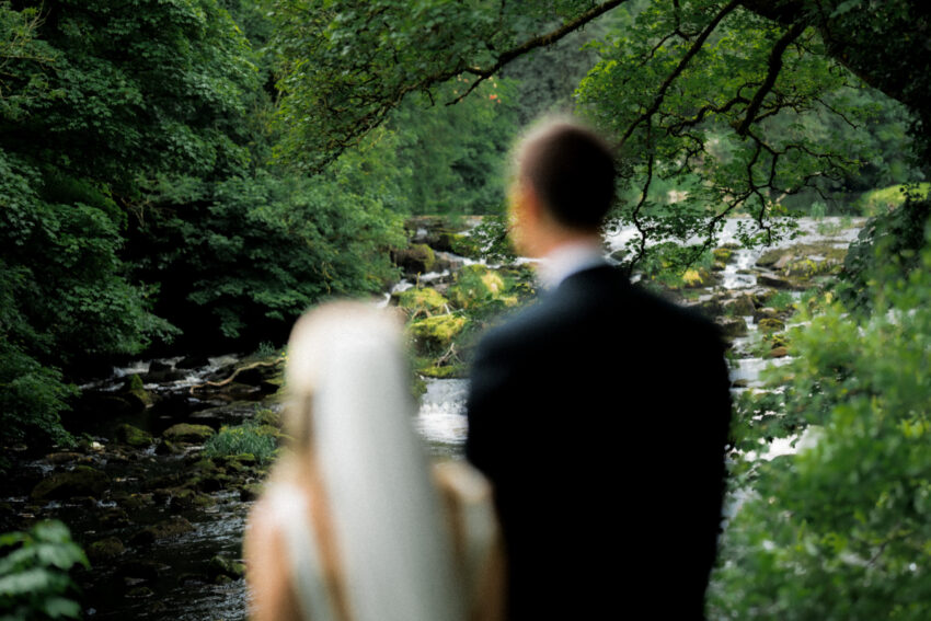 A couple at the wedding in Northern Ireland. In the background is beautiful green Irish countryside.