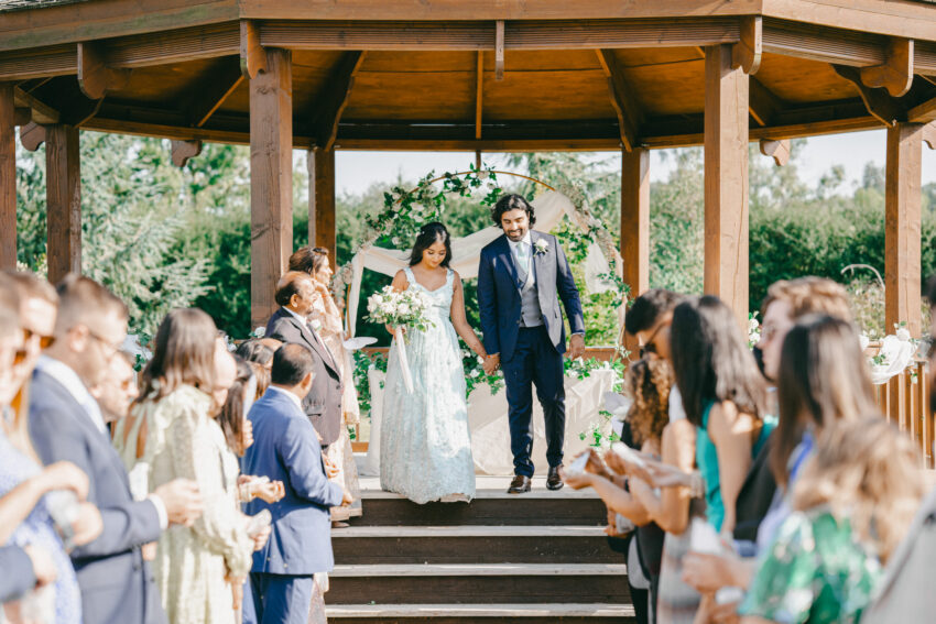 Natural wedding day moment photographed by a Lincolnshire wedding photographer as the couple walk back down the aisle surrounded by guests.