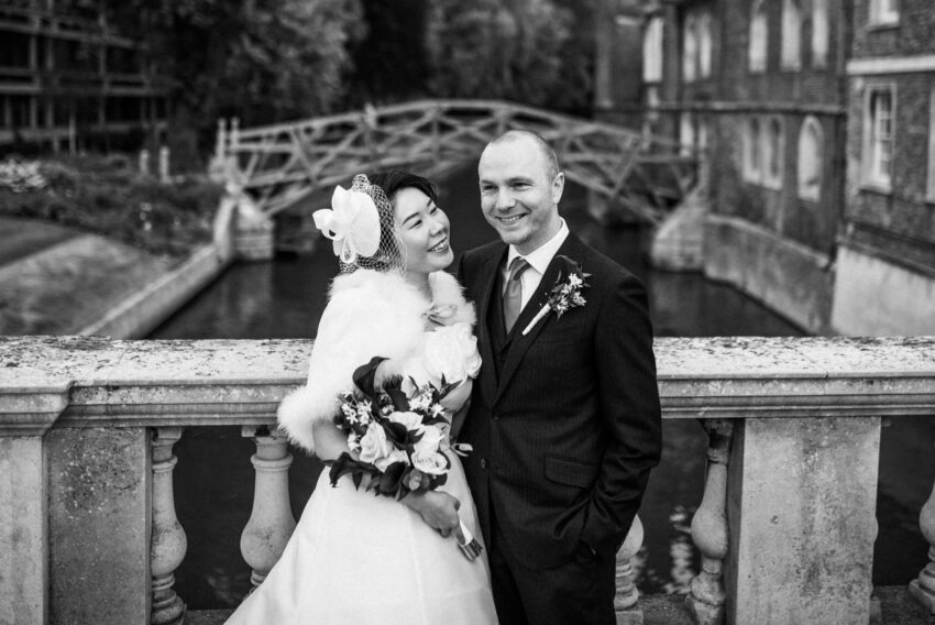 A couple pose in front of the Mathematical Bridge in Cambridge.