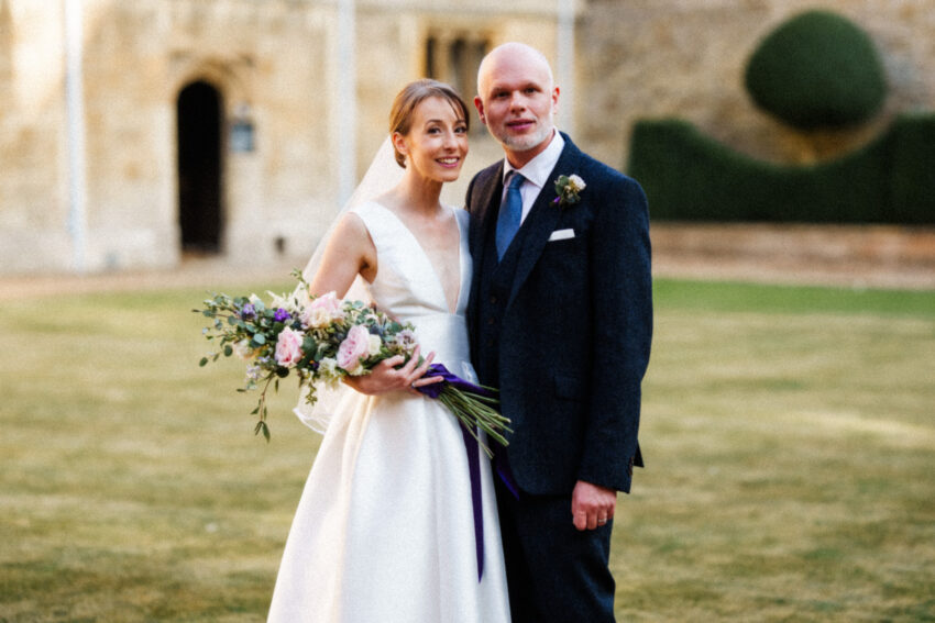 Simple, relaxed portrait of the bride and groom outside Gonville and Caius College