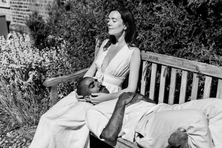Couple resting together on a bench during their pre-wedding shoot photographed in black and white